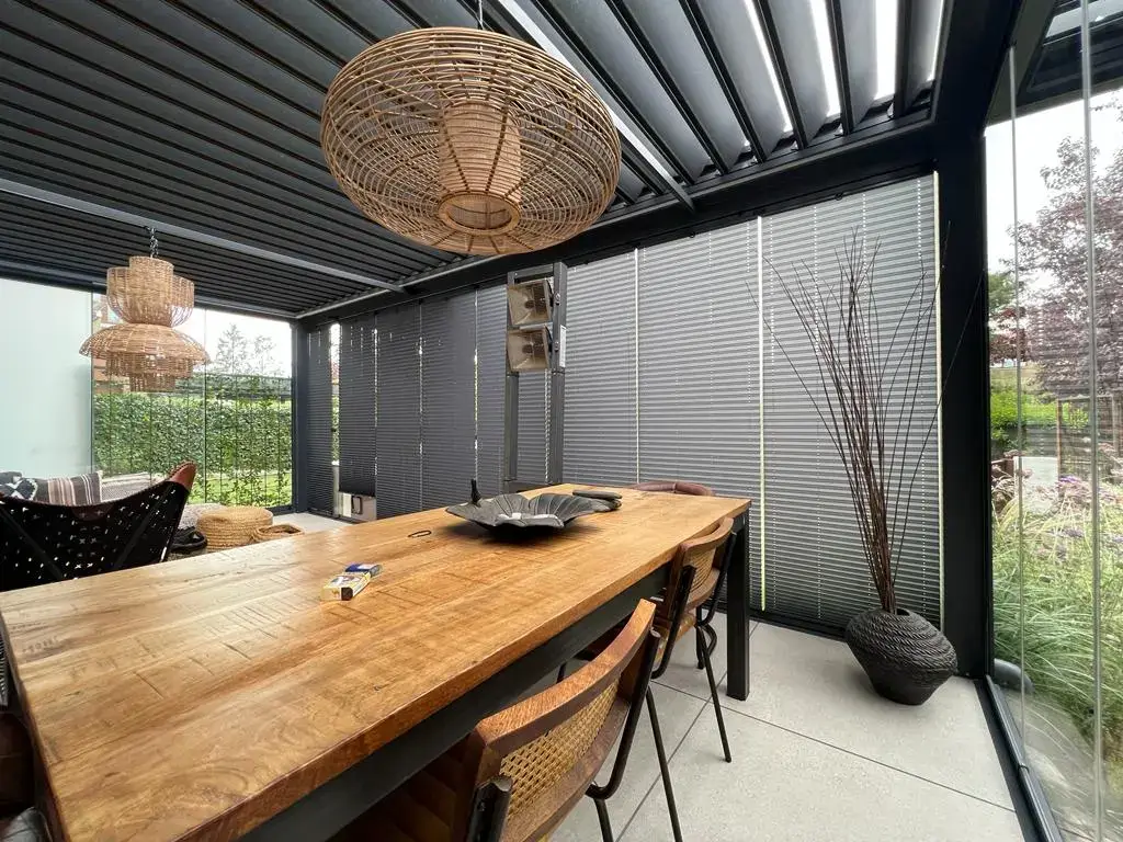 Terraza con cierre de cristal y cortinas plisadas