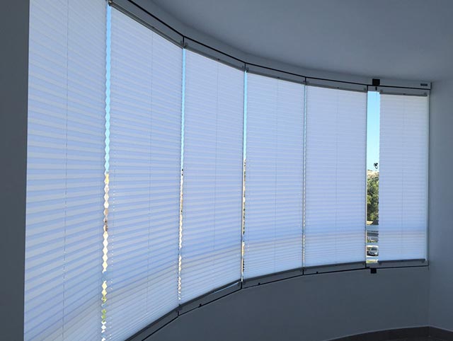 cortinas plisadas en terraza de cristal curva